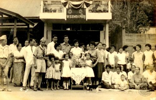 วันอังคารที่ ๑๗ มีนาคม พ.ศ. ๒๕๐๒ มีราษฎรเตรียมเฝ้าฯ รับเสด็จ และทูลเกล้าฯ ถวายของที่ระลึก บริเวณถนนพัทลุง ซึ่งเป็นเส้นทางเสด็จฯ ในภาพเป็นบริเวณหน้าบ้าน นายเสถียร วีรวรรณ ปลัดอําเภอสิเกา (แต่งเครื่องแบบยืนกลาง)  (ภาพรับมอบจากนางอาภา สัมพันธ์วิวัฒน์)